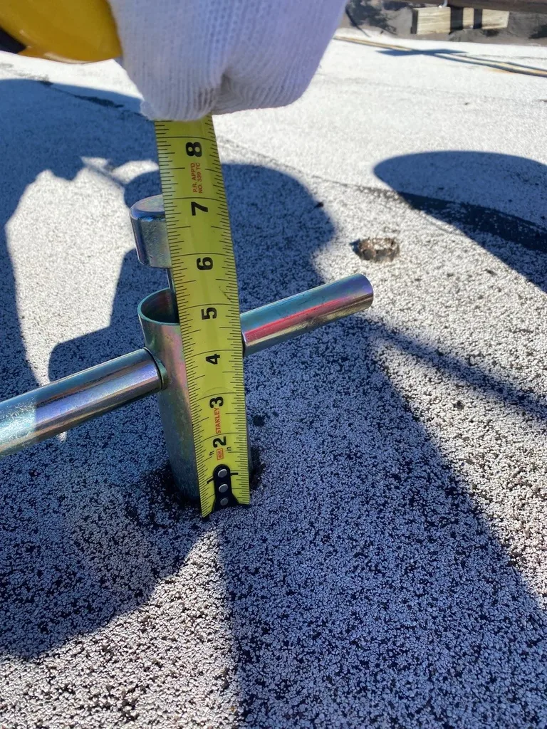 Roofing technician taking measurements with a tape measure during damage documentation — 5 Star Roofing