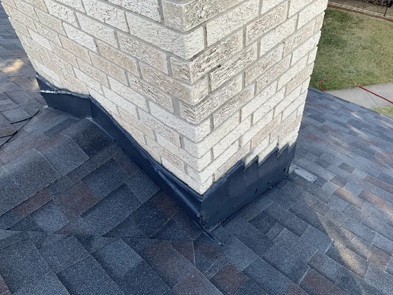 Finished chimney flashing and cricket detail on a completed shingle roof — 5 Star Roofing quality inspection